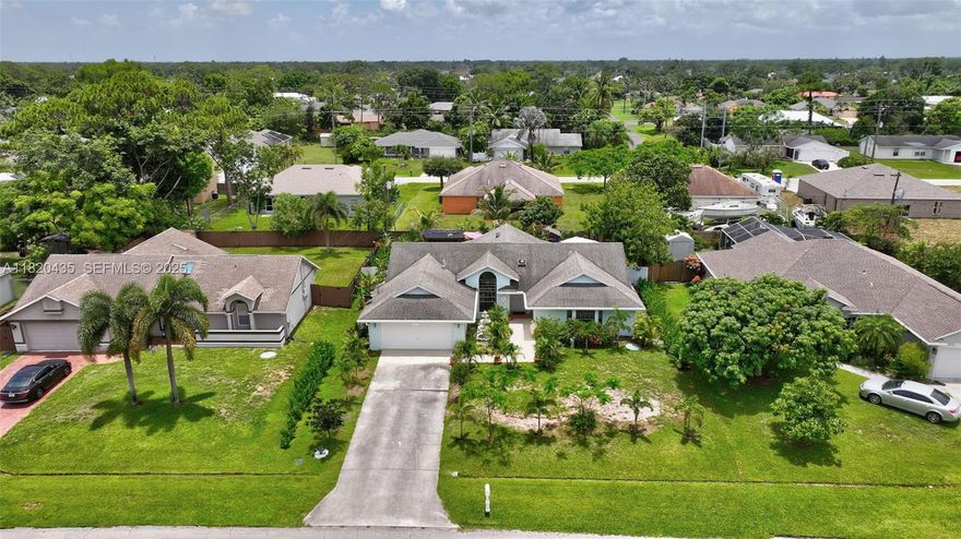 Price Improvement alert! Located at just 20 minutes from the beach, and less than 10 minutes from the Turnpike. This meticulously maintained property boast a versatile layout with plenty of closets. Featuring 3 bedrooms, 2 bathrooms, 2-car garage, inside laundry room, formal dining room, kitchen/family combo, tile/laminated flooring, oversized screened lanai overlooking a beautifully designed paved patio. The stunning landscape includes fruit trees and exotic plants, providing endless entertainment for nature lovers. The kitchen counts with stainless still appliances, modern backsplash, breakfast bar, and wide windows ideal for family interaction while enjoying the lanai during special celebration. New AC to be installed before closing plus $10k buyers credit.