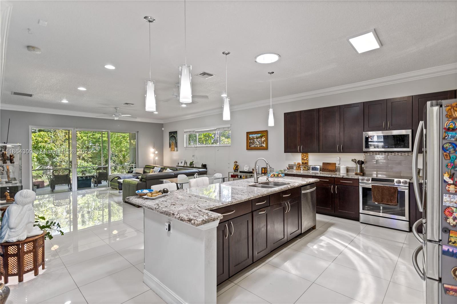 This beautifully maintained single-family home, built in 2014, offers 3 spacious bedrooms and 2 full bathrooms in a bright and open layout designed for modern living. The home features high ceilings, 24x24 porcelain tile throughout, elegant crown moldings, and Solatubes that bring in additional natural light. This modern kitchen is a standout, complete with granite countertops, stainless steel appliances, and a center island. Additionally, this property comes equipped with high-impact windows, a one-car garage with a Wi-Fi-enabled remote door, a two-car driveway, custom cabinetry in the garage for extra storage, and an EV charger for electric vehicle owners! This move-in-ready home combines comfort, convenience, and a prime South Florida lifestyle!