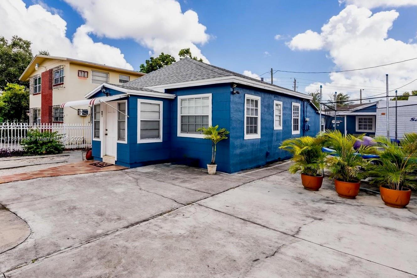 Legal Duplex operating as a Triplex, offers a large primary unit 3/1 with a studio attached and back detached 1/1 building. With a fresh blue exterior modern finishes and updated interiors this property is perfect for investors or owner-occupants seeking substantial rental income. The kitchens have been upgraded with new cabinetry and the open living spaces feature new wood-look flooring and large windows that bring in natural light. This property located right off West Flagler. The property boasts a large amount of parking and generates ~ $6,150 per month in rental income making it a great income-producing opportunity.