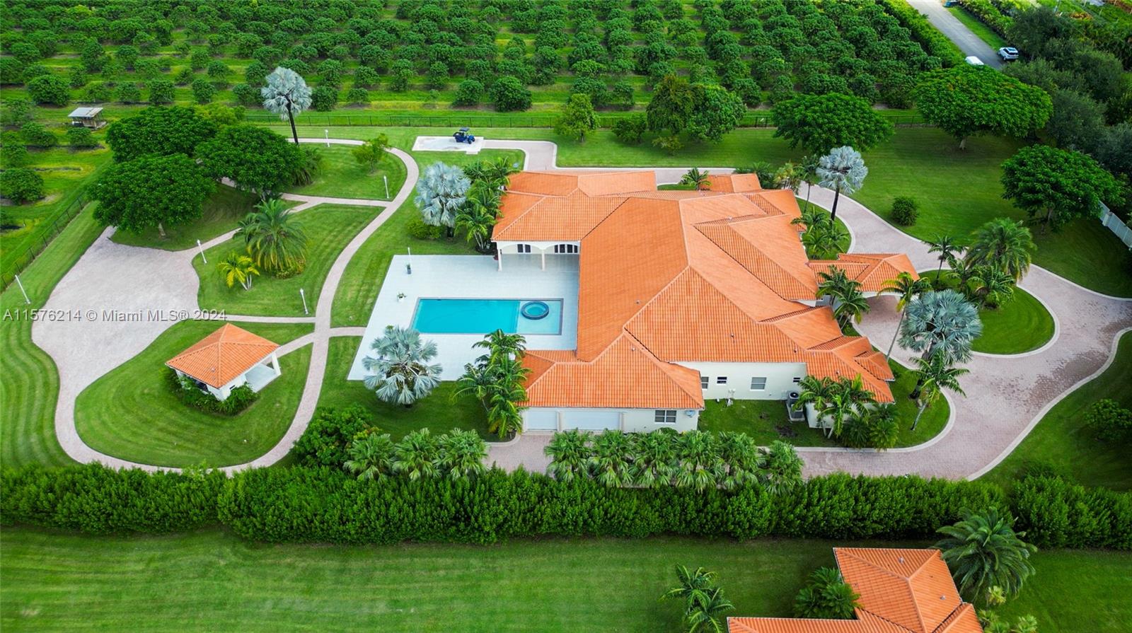 For the first time, this mansion is on the market. Set on 5 acres, the estate offers landscaped gardens, a pool area, and a lychee tree grove. A private entrance opens into a grand room with triple-height ceilings.
The modern Mediterranean-style home features 7 bedrooms, including 2 primary suites, 6 bathrooms, 2 half baths, 3 offices, and 6-car garage. The expansive kitchen suits both daily living and entertaining.
Amenities include a gazebo, party room, covered terraces, walking path. Adjacent land is available, offering the chance to expand into an equestrian estate or sports retreat. Enjoy stunning sunsets every evening.