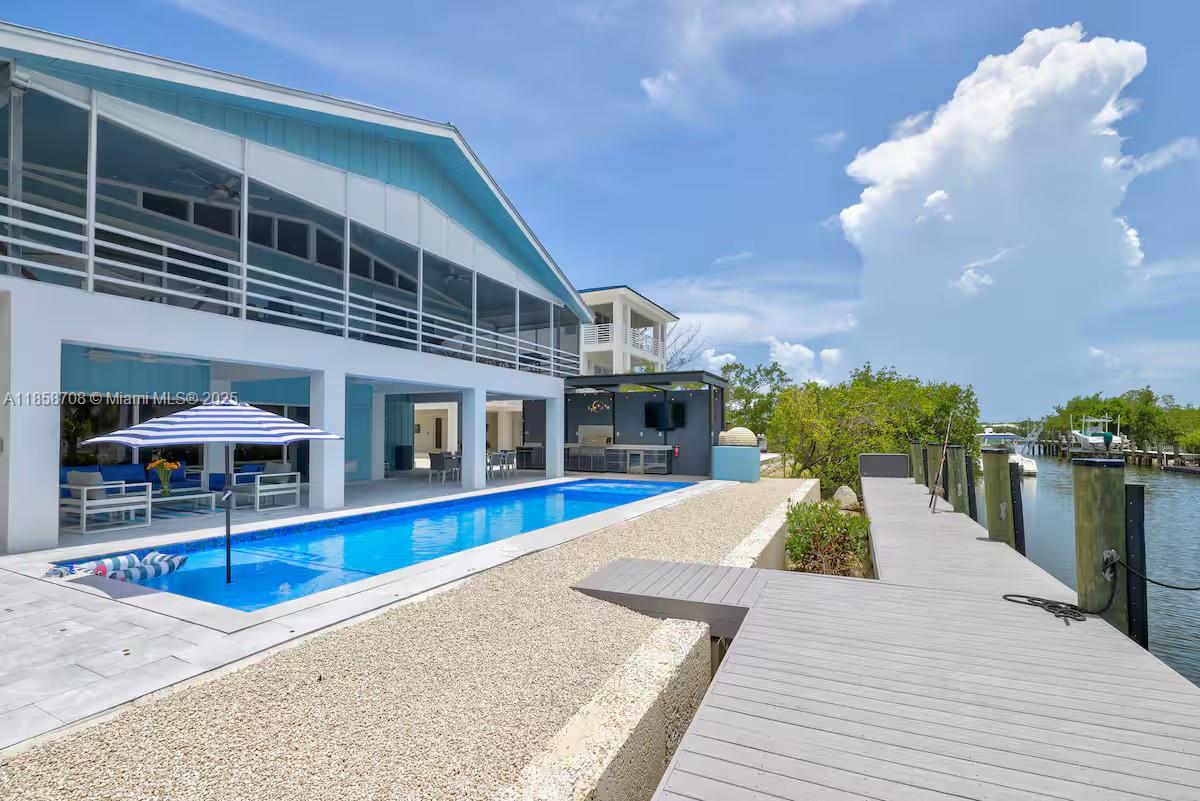 Fully remodeled from the ground up, this 3BR/2.5BA canal-front home offers modern style and island charm just minutes from the bay. A 40-ft pool, jacuzzi, and full outdoor kitchen set the stage for unforgettable gatherings, steps from your private 80-ft dock with direct bay access. Inside, bright open living spaces flow to a covered terrace perfect for dining and sunset views. Game area, wood-burning oven, and quality finishes make this move-in-ready retreat ideal for boaters, families, and Keys living at its best.