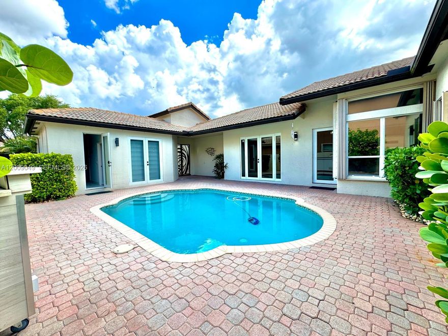 COURTYARD HOME -  Rare opportunity to own a beautifully remodeled home in one of the best locations in Pembroke Pines, within the prestigious gated community of Pembroke Shores. This bright and spacious 3-bedroom, 3-bath residence offers a private courtyard oasis with a lighted pool and a fully renovated guest/in-law suite, ideal for multigenerational living or added privacy. Features include a brand-new roof (2025), new pool pump, elegant marble floors in kitchen and dining areas, remodeled bathrooms, impact glass French doors, accordion shutters, dedicated laundry room, and a finished garage with epoxy flooring, A/C, and insulated garage door. Spacious living and family rooms filled with natural light. Lawn and pool maintenance included. Move-in ready and designed for comfort, functionality, and style. This property stands out from anything else currently on the market.