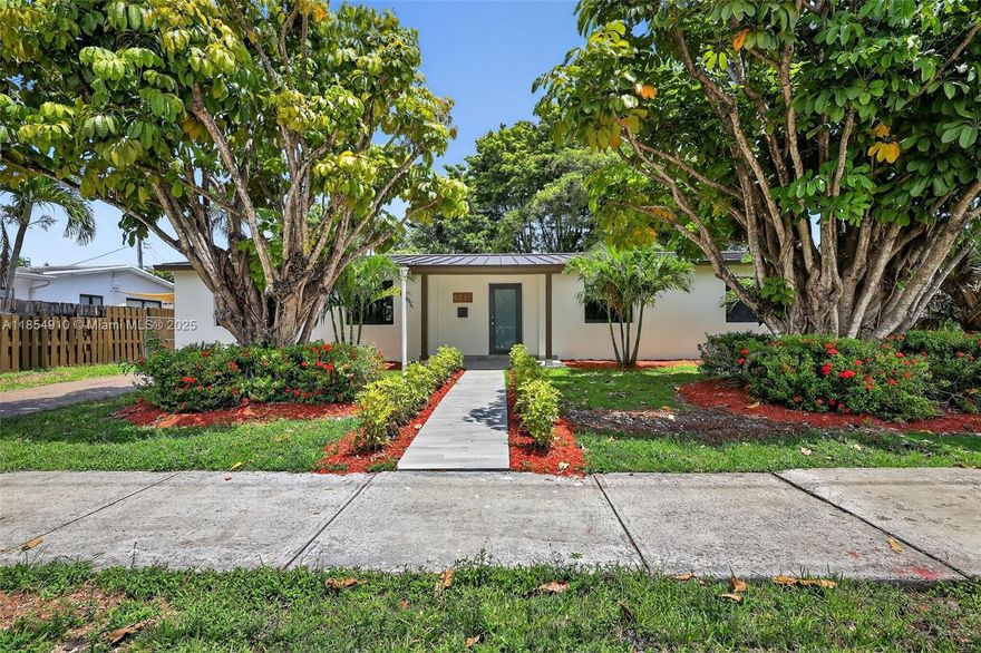 This stunning home is truly turnkey. Beautiful kitchen and bathrooms. Kitchen highlights built-in wine cooler, spacious pantry, accent wall with open shelves, custom made kitchen cabinets, quartz counter tops and stainless-steel appliances. Bathrooms nicely decorated with contemporary cabinets and hardware. Uniform slate grey tile throughout the house. Convenient split bedroom layout. Separate laundry room. New Metal Roof 2025. All impact windows and doors. The spacious backyard has plenty of room for a pool and lounge furniture. Fenced in backyard. Bigger than tax roll. Great neighborhood with nearby excellent schools, restaurants and entertainment. Must See!