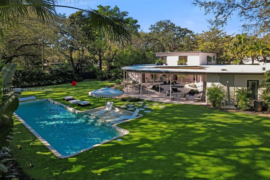 Shoreland – The Revitalized Panorama House.  A rare opportunity to own one of Miami Shores’ most architecturally significant estates. Originally designed in 1950 by noted architect Joseph DeBrita, this iconic midcentury modern residence has been comprehensively reimagined by Shoreland Group.  Set on a 21,450 SF parcel—among the largest in the village—the 5,348 SF home is positioned beneath mature oaks to maximize privacy and outdoor living. Interiors offer 4,370 SF under air with dual primary suites, an in-law suite with kitchenette, cinema/game room, laundry, and attached garage.  Refined, cohesive interiors blend architectural authenticity with warm, modern design. A meditation garden anchors the home, complemented by 1,000+ SF of covered entertaining space, summer kitchen, heated 42-foot saltwater lap pool, fire pit, outdoor shower, and lush tropical grounds.  Discreet from the street yet transformative within, Shoreland delivers pedigree, scale, and experiential design in one singular offering.