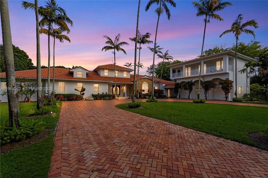 Set on a gated full acre in the heart of Pinecrest, this elegant 6-bedroom, 7-bath estate blends modern upgrades with timeless design, offering exceptional privacy, scale, and seamless indoor–outdoor living. Bright interiors feature soaring ceilings, expansive glass doors, and a layout designed for today’s lifestyle. The recently renovated kitchen and family room form the centerpiece of the home. The chef’s kitchen showcases a dramatic waterfall quartzite island, full-height quartzite backsplash, and upgraded Thermador appliances including induction cooktop, double ovens, and built-in refrigeration. Custom cabinetry, designer lighting, and generous prep space make it ideal for everyday living and entertaining. A private guest suite above the 3-car garage offers its own entrance, living/sleeping area, kitchenette, full bath, and storage—perfect for guests, in-laws, an au pair, office, or studio. The split floor plan enhances privacy, with the primary suite featuring a spa-style bath, dual vanities, jacuzzi tub, walk-in shower, and veranda access. Resort-style outdoor spaces include a pool, summer kitchen, expansive patio, mature fruit trees, and basketball court. Additional features include hardwood floors, copper plumbing, a Bahama tile roof, and community security. Minutes from top Pinecrest schools, parks, and shopping.