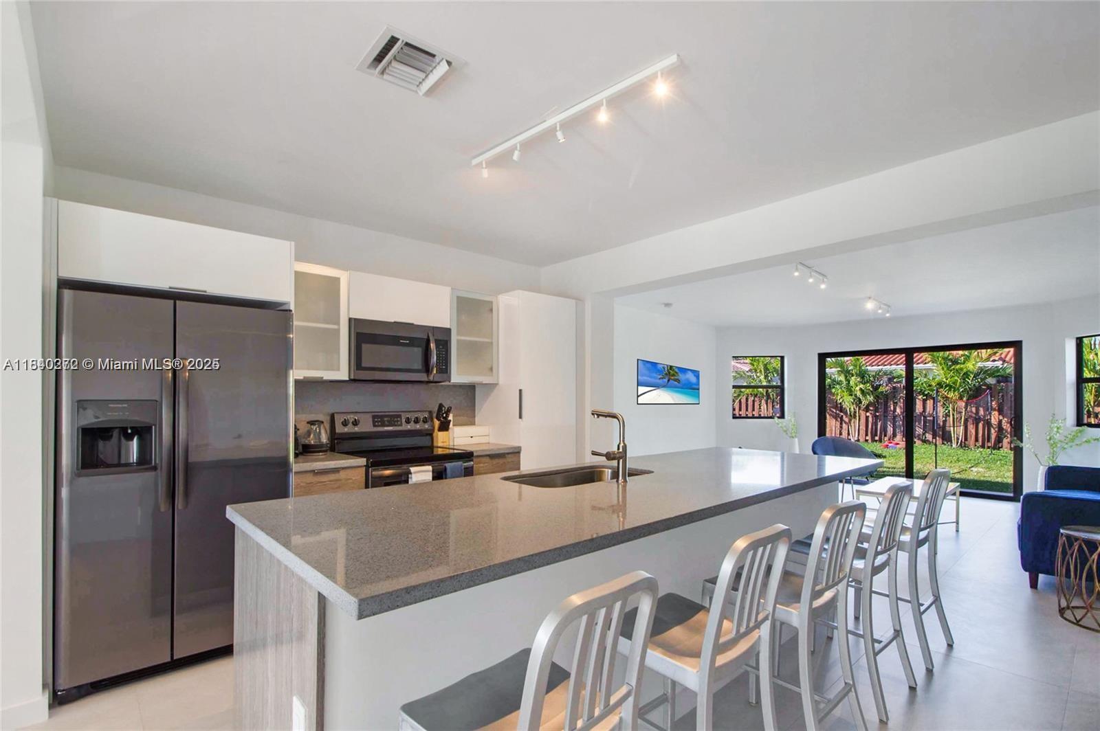 A stunning property in North Bay Village, meticulously renovated to perfection! Featuring 4 spacious bedrooms, 3 bathrooms, and 1,877 square feet of living space, this home boasts a custom kitchen with a chef's island, inviting living and family rooms, and hurricane-impact windows and doors. Updated in 2020 with new A/C, electrical, and plumbing systems, it includes designer closets in every bedroom, sleek porcelain floors, and smart lighting throughout. Abundant windows fill the home with natural light, seamlessly connecting to a private backyard oasis complete with a pool.