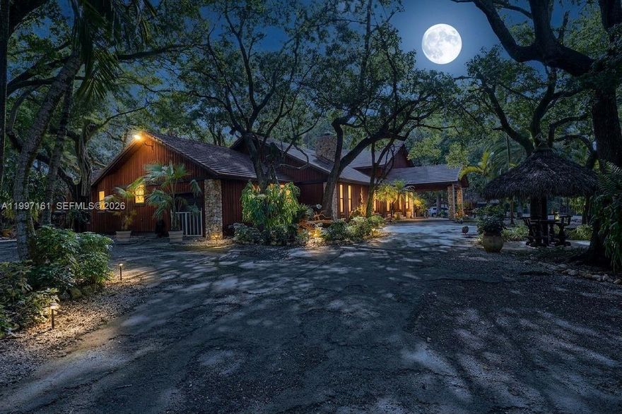 Discover the potential of this exceptional property located in the peaceful and fast-growing Redland area of South Miami-Dade. Set among mature greenery and wide-open spaces, this rare blend of privacy, space, and opportunity—perfect for buyers seeking room to grow, invest, or create their ideal lifestyle.
This extraordinary estate offers 4–5 acres of private, fully usable land with unmatched versatility. The main residence features 5 bedrooms & 3 bathrooms, built with solid concrete block construction accented by red cedar, impact windows & doors, and a warm, inviting fireplace. A tucked away 1/1 guest house for extended family or guests, and a dedicated office house, ideal for work. Designed for entertaining, enjoy expansive outdoor living spaces, a full exterior kitchen, BBQ, and multiple tiki huts with designated entertainment areas ideal for gatherings, events or meditation. Equestrian and agricultural amenities include horse stables, animal barns, and a private aviary, perfect for bird enthusiasts or specialty use. The open acreage supports livestock, farming, or recreational pursuits, all while offering privacy and serene country living with convenient access to major roads and amenities. Minutes away from the Florida Keys.