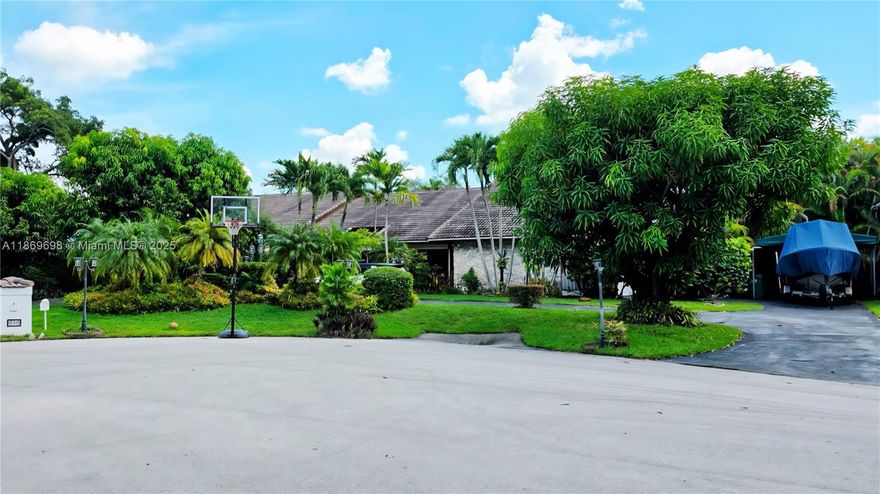 Stunning large 5/4 Home with Pool in Exclusive Pine Bay! Situated on a quiet cul-de-sac in one of Pine Bay’s most sought-after neighborhoods. Offering a split floor plan, this home boasts a spacious master suite with an attached private office. The open-concept kitchen features a cozy breakfast area overlooking lush landscaping and the pool, creating the perfect relaxed mornings. Enjoy multiple living spaces, including a formal living and dining room plus a large family room, perfect for entertaining and family gatherings. Step outside to your private oasis with a summer kitchen. Accordion hurricane shutters provide peace of mind, while a wine cooler adds a touch of luxury. Highlights include a 2-car garage, separate indoor laundry, and exclusive private police patrol for extra security