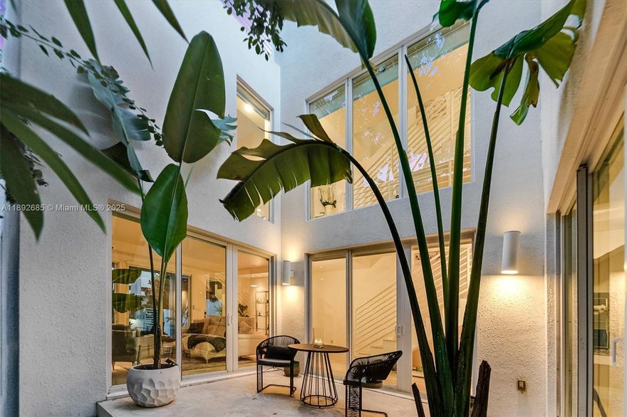 The "Glasshouse" is a modern architectural gem in the heart of Coconut Grove! This striking corner townhome offers 3 bedrooms, 3.5 baths, and a huge private rooftop terrace with a new entertaining kitchen island—perfect for gatherings under the stars. Light-filled interiors feature 11-ft ceilings, Italian travertine floors, and floor-to-ceiling impact glass for seamless indoor-outdoor living. The gourmet kitchen boasts stainless steel appliances, a gas cooktop, and ample cabinetry. The primary suite includes a Jacuzzi and a double shower. The lush outdoor oasis features a tranquil water feature. Additional highlights: two balconies, a full laundry room, walled and gated privacy, and a rear-entry two-car garage with direct kitchen access—all with no shared maintenance fees.