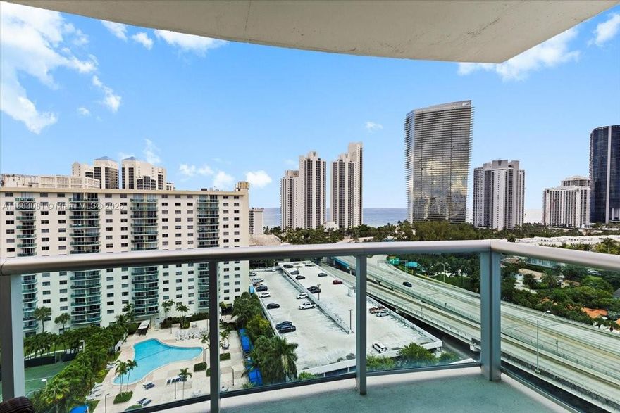 High-floor 2-bed, 2-bath plus den in Oceanview B, just below the penthouse. Bright east-facing balcony with partial ocean views between buildings. Den is currently used as a 3rd bedroom. Assigned parking on the 1st floor, next to the service elevator, which opens just steps from the unit entrance, is ideal for everyday convenience. The building offers 2 pools, tennis courts, a gym, and 24-hour security. Walk to the beach through the nearby public access. One of the most secure and well-managed condominiums in Sunny Isles. Ideal for those seeking comfort, a great location, and a desirable lifestyle.