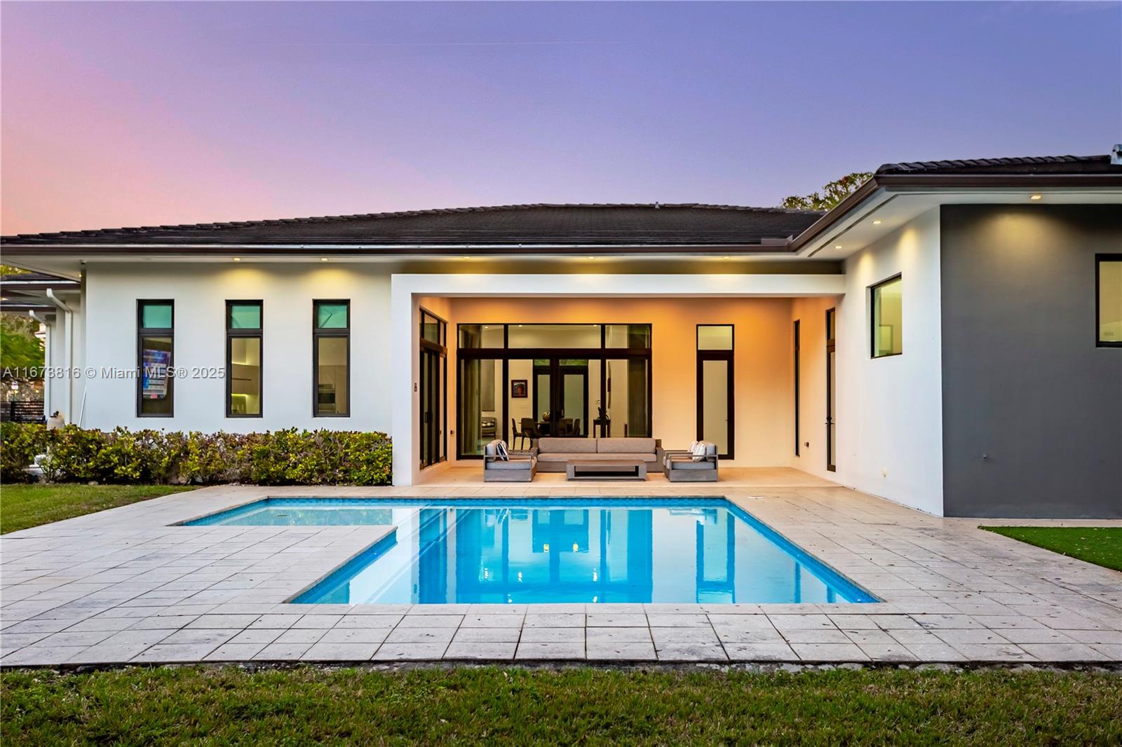 Exquisite contemporary one-story estate in Pinecrest, built in 2018, featuring 5 en-suite bdrms & 6 baths w/ 12 FT CEILINGS on a gated 26,528 SF lot! A grand foyer leads to formal living & dining areas, seamlessly connecting to the gourmet kitchen & family room. Kitchen boasts Italian cabinetry, Wolf/Sub-Zero appliances, dual dishwashers, heating drawer, & large walk-in pantry. Opulent primary suite includes seating area, walk-in closet, makeup station, pool access, & spa-like bath w/ dual water closets, a tub, shower, & double vanity. Sliding doors open to covered terrace, pool w/ lounging area, & large backyard w/ turfed mini soccer field. Add'l ftrs: 2-car gar, built-in speakers, walking to Suniland Plaza & close to expressways & top schools. It's not Miami, It's Pinecrest!