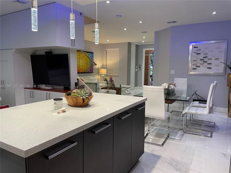 Live well with modern comfort and elevated living in this fully remodeled 3-bedroom, 2.5-bathroom townhouse in the heart of Doral. Designed with both style and functionality in mind, this home features a bright, open-concept layout on the first floor with sleek tile flooring throughout and a seamless flow between the living, dining, and kitchen areas—perfect for entertaining or everyday living. The contemporary kitchen is equipped with premium GE appliances, a whisper-quiet Miele dishwasher, and a state-of-the-art induction cooktop, offering both efficiency and sophistication. Upstairs, you’ll find durable heavy-duty laminate flooring, spacious bedrooms with floor-to-ceiling closets complete with custom organizers, and blackout blinds for privacy and comfort. The primary suite boasts a thoughtfully designed closet with a hidden safe for added security. This home is loaded with high-end upgrades, including impact windows, a full security camera system with facial recognition, surround sound throughout, and ambient lighting that enhances every space. Enjoy a whole-home water softener system with 9.5 pH alkaline drinking water at the kitchen sink and 7.5 pH throughout. Step outside to a paved patio—ideal for relaxing or hosting guests. Includes a 1-car garage plus driveway parking for 2 cars. Conveniently located near major highways, top-rated schools, parks, shopping, and dining. Move-in ready.