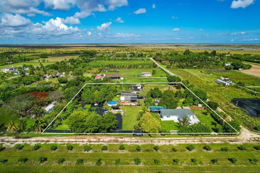 SELLER FINANCING AVAILABLE! Take advantage of this amazing opportunity to own over 2.5 acres of land in Miami, Florida!  This corner lot has 4 independent entrances with a home of 1,430 square feet, 2 master bedrooms, 1 studio room and 2 full bathrooms, each with a jacuzzi bathtub.  Lot also features 2 electricity poles with power meters, one of which is next to a cleared lot of over 15,000 square feet where you can build your dream home, according to Miami Dade County Code.  Additional features for this lot are 6 gazebos for a total of 900+ square feet, roof replaced in 2019, new impact windows & doors, water softener system with reverse osmosis system, 4 water wells on the property, pre-installed surveillance system, swimming pool, wood and chain link fence, and over 150+ fruit trees.