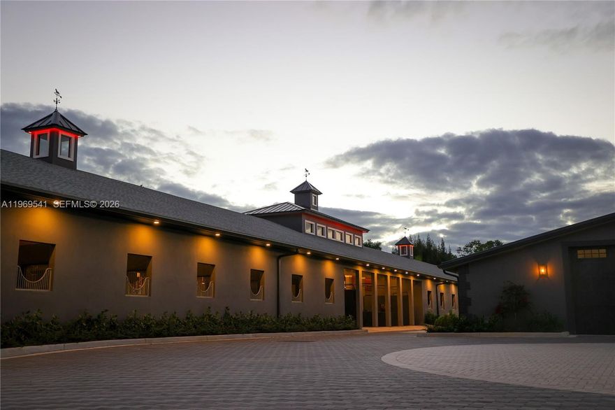 When only the best will do! This is not just an equestrian property — it’s a world-class show barn, designed for riders operating at the highest level of the sport. The 5-acre gated facility offers durability, longevity & elite performance just 20 minutes from Miami, 1 hour from Wellington & 30 minutes from Fort Lauderdale Beach, w/ easy access to multiple international airports. The concrete barns feature 38 Rower & Rube stalls w/ premier footing, Nelson automatic watering systems, 24-hour surveillance & 16 run-outs. There are 12 oversized, irrigated grass paddocks w/ permanent concrete run-in sheds & fans for year-round comfort. Broward County’s largest covered indoor arena, built w/ a specialized isolation system, is complemented by outdoor arenas, professional dressage mirrors, a hot walker, treadmill & dry treadmill. All stalls connect to a full underground drainage system to eliminate flooding. A 3-story luxury clubhouse overlooks the arena & includes indoor/outdoor viewing areas, management offices, a bar & a beautifully appointed tack room. Above is a 2-bedroom, 2-bath apartment ideal for a trainer or owner, plus a separate 3-bedroom staff apartment & full grooming facilities. 3 trailers & select equestrian equipment are included. Direct trail access connects to Vista View Park & the Florida Trail network. Near American Heritage School. New Price – Reduced from $7.9M to $7.299M.