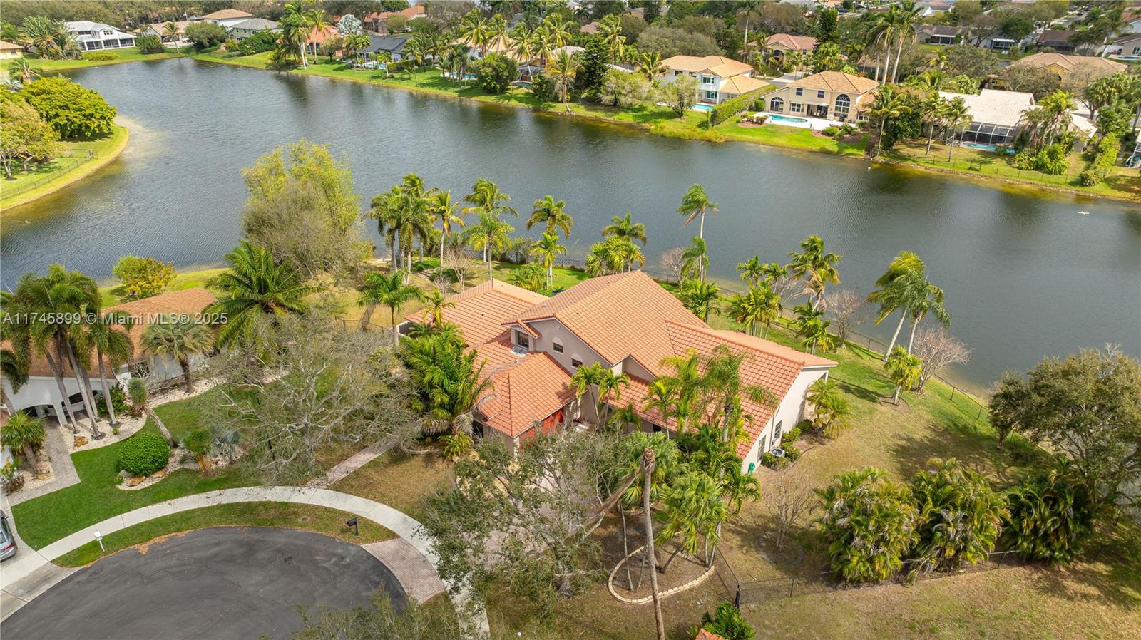 Stunning Lakefront Pool Home in Pasadena Estates! This 5 bedroom, 4.5 bathroom home sits on a ½-acre cul-de-sac lot. Primary suite on the first floor with 2 full bathrooms, plus a guest/in-law suite w/private bath, large walk-in closet. Upstairs, 3 additional bedrooms. Designed for both comfort and entertaining, the home features a large kitchen with plenty of workspace, formal dining, living room, family room. Vaulted ceilings throughout the main living areas create an open, airy feel, while French doors lead to your tropical backyard retreat. Lush landscaping & swaying palm trees overlooking the lake. Impact windows upstairs and partial impact protection downstairs, 2015 roof. Excellent potential for expansion! This home is a must see in one of Davie’s most sought-after communities!!
