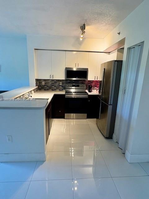 Welcome to this spacious 2 bed, 2 bath condo in a resort-style community! Enjoy peace of mind with a guarded gate and secure building entrance. The home features tile floors throughout, stainless steel appliances, and turf on the private patio. Community amenities include tennis courts, sparkling pool, and brand-new washing machines and dryers for added convenience. Well-maintained with no assessments. Perfect blend of comfort, security, and lifestyle!
