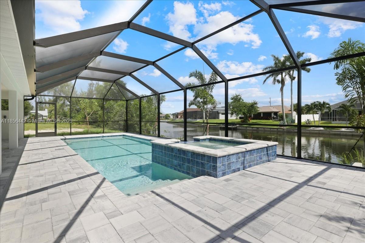 WATERFRONT PARADISE ON CITY WATER/SEWER WITH DUAL PRIMARY SUITES & HEATED POOL! The bright, airy great room features soaring ceilings and a 12-foot triple slider inviting natural light. The gourmet kitchen features soft-close, all-wood cabinetry, quartz countertops, stainless steel appliances, and an oversized walk-in pantry. The primary suite is large enough for a king-sized bed and a cozy seating area. Enjoy direct lanai and pool access, plus a spa-inspired ensuite with a freestanding soaking tub and walk-in shower. The second suite includes a full bath and doubles as a convenient pool bath. This home offers impact windows, no flood zone for peace of mind, and a 10-year structural warranty. This is The Paradise Cove Plan.