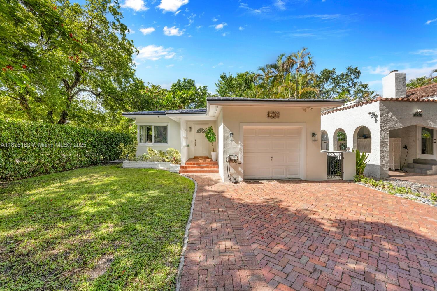 Charming & inviting 2-bedroom, 2-bathroom home on a peaceful, tree-lined corner lot in highly desirable North Coral Gables. Minutes from scenic parks like San Jacinto, Majorca, Venetia, & the iconic Granada Golf Course, this home offers the perfect mix of tranquility & convenience. A brand new roof will be completed by July 2025, providing long-term value & peace of mind. Inside, enjoy impact windows, original hardwood floors, spacious bedrooms, & updated bathrooms.The cozy front porch, privacy hedges, open patio, & generous yard create great spaces for relaxing or entertaining. The bright kitchen features granite countertops, stainless steel appliances, & direct access to the one-car garage.Elegant archways, natural light, & timeless details throughout give this home a warm, classic feel.