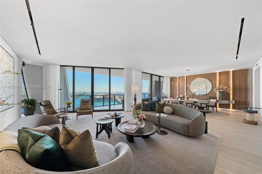Perched on a high floor at One Thousand Museum, this meticulously appointed 4-bedroom, 5.5-bathroom residence commands sweeping panoramas of Biscayne Bay and the city from sunrise to sunset. Spanning 4,600 square feet of interior living with 780 square feet of private terrace space, this is Miami luxury at its most elevated. Step through a monumental glass entry door into a foyer finished in rich oak millwork and handcrafted Venetian stucco walls. The main living area is anchored by iconic Fendi sofas and a Baxter dining table surrounded by custom millwork, while a dedicated wet bar with Sub-Zero wine refrigerator makes entertaining effortless. The custom Italian Poliform kitchen stuns with dramatic onyx marble countertops and a full suite of Gaggenau and Sub-Zero appliances. The primary suite offers a serene marble morning bar and a bespoke Molteni closet system. The Carrara marble bath features a rainfall shower, spa-caliber soaking tub, and Studio RODA privacy screen. Guest rooms are beautifully appointed with Molteni cabinetry and custom built-in bookcases. Dornbracht and Duravit fixtures throughout, with Crestron automated shading, Sonos audio, and Ornare laundry cabinetry completing this extraordinary turnkey residence. Offered fully furnished.