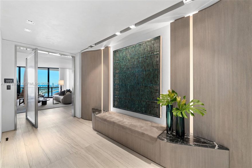 Perched on a high floor at One Thousand Museum, this meticulously appointed 4-bedroom, 5.5-bathroom residence commands sweeping panoramas of Biscayne Bay and the city from sunrise to sunset. Spanning 4,600 square feet of interior living with 780 square feet of private terrace space, this is Miami luxury at its most elevated. Step through a monumental glass entry door into a foyer finished in rich oak millwork and handcrafted Venetian stucco walls. The main living area is anchored by iconic Fendi sofas and a Baxter dining table surrounded by custom millwork, while a dedicated wet bar with Sub-Zero wine refrigerator makes entertaining effortless. The custom Italian Poliform kitchen stuns with dramatic onyx marble countertops and a full suite of Gaggenau and Sub-Zero appliances. The primary suite offers a serene marble morning bar and a bespoke Molteni closet system. The Carrara marble bath features a rainfall shower, spa-caliber soaking tub, and Studio RODA privacy screen. Guest rooms are beautifully appointed with Molteni cabinetry and custom built-in bookcases. Dornbracht and Duravit fixtures throughout, with Crestron automated shading, Sonos audio, and Ornare laundry cabinetry completing this extraordinary turnkey residence. Offered fully furnished.