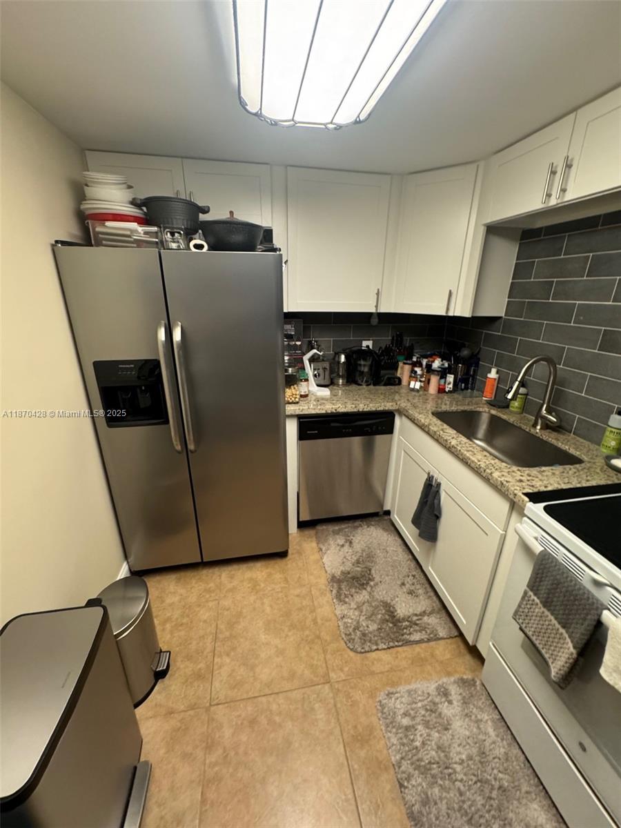 This remodeled, bright and spacious 1/1.5 (large 800 sq ft) 1st floor condo in the ALL Ages Deerfield Pines Condo minutes from the beach features an updated kitchen featuring white shaker cabinets and granite countertops with stainless steel appliances, updated bathrooms & Flooring. Tiled throughout and water-proof vinyl in the bedroom! All in One Washer/Dryer in the bathroom. Your screened in balcony- steps from the pool & BBQ/courtyard area- also has a storage room & SHUTTERS! Bedroom window is hurricane IMPACT. Enjoy heated pool, gym, BBQ area, billiards, sec cameras and clubhouse. Roof replaced recently and building parking lot paved, interior/exteriors painted and floors. Can purchase with 5% down. Sold furnished($) or unfurnished. NO special assessments. NO LEASING, NO PETS.