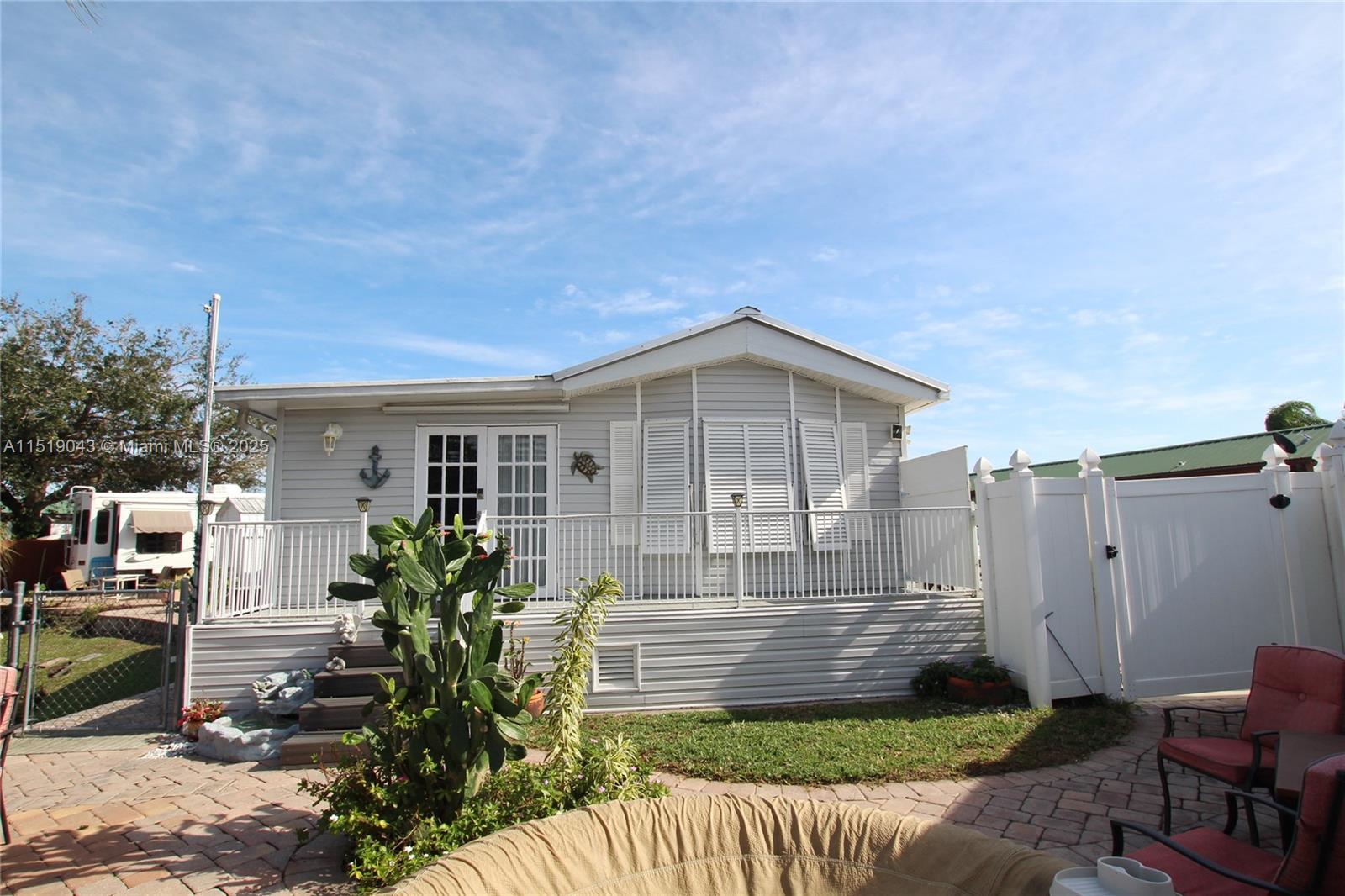 BIG O - Active Community - double lot with a beautiful park model. It has a patio area with outdoor furniture, a walk way to the garage which has a screen room on the back side. It looks over the pond and is a spectacular view. It is a million dollar view. The pond is stocked with fish and you can sit and fish off your yard. New 2022 Metal Roof fully permitted, 2022 new laminate flooring. A half bath with a washer and dryer. 2022 installed French Doors, A/C 2021, Hot Water Heater 2021, 2022 New light fixtures in the kitchen, Bahama Shutter and regular hurricane shutters. There is Botchy Ball, pool, Bingo, cards, line dancing, corn hole, fishing tournaments, craft shows. You have it all here. Come and join the fun.