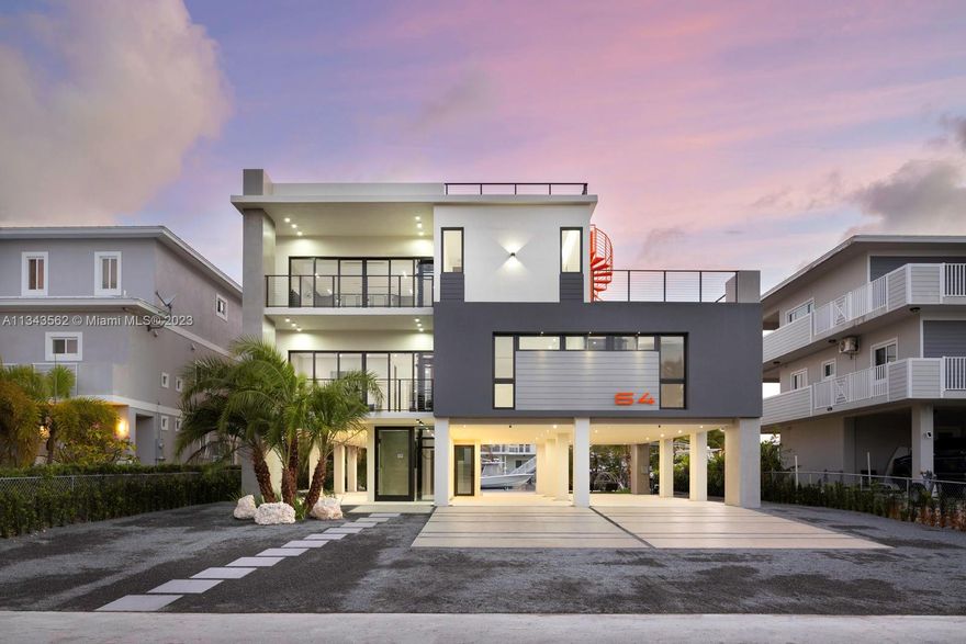 A treasure awaits in Key Largo. Welcome to this new construction 6 bedroom, 5 bathroom, 3-story waterfront residence spanning 4,246 sq. ft. It represents the epitome of modern minimalism, clasped and surrounded with wrought iron terraces while dominating in scaled-up ebony and white, with a pop of orange grandeur. One of the highlights of the residence is its extraordinary outdoor spaces ensconced in royal palms and envy-colored flora. It features an infinity edge pool detailed with stools and a 15ft bench with massage jets. In addition, perfect for the yachting lifestyle, residents will find a private 60ft. boat dock. Extra features include a glass wine display for up to 500 bottles, a theater room (cabled and insulated), and a summer kitchen on the third-floor covered terrace.