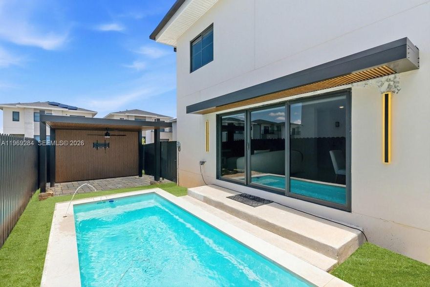 This modern new construction features 5 bedrooms, 3 remodeled bathrooms, impact windows, porcelain tile throughout, and a smart home system. Includes a 19' x 7' in-ground pool, pergola will Not convey, aluminum gates, and 5-camera security system. Bedrooms come with blackouts and blinds, plus modern drain gutters and custom upgrades throughout. Prime location near Fresh Market, Zoo Miami, and just 30 minutes from the Florida Keys. Stylish, secure, and move-in ready! The open-concept design is perfect for entertaining, with seamless indoor-outdoor flow. Spacious layout offers comfort and privacy for families or guests. Ideal for those seeking luxury living in a growing area.