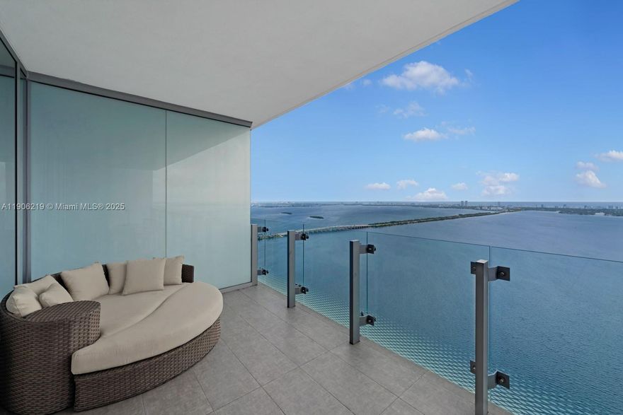 The only move-in ready 03-line at Missoni Baia! This stunning 4-bedroom + family room, 6-bath residence offers floor-to-ceiling glass on all sides, filling the home with natural light and showcasing breathtaking bay, ocean, and skyline views. The living room is surrounded by windows, creating a bright, airy ambiance that seamlessly connects to two large patios overlooking the water. Features include a private elevator entry, high ceilings, built-out closets, designer window treatments, and top-of-the-line WOLF & Sub-Zero appliances. Residents enjoy a hotel-style lifestyle with two pools, a tennis court, valet parking, spa, and fitness center—all with the unmistakable Missoni touch and a seamless blend of comfort, elegance, and resort-style living every day.