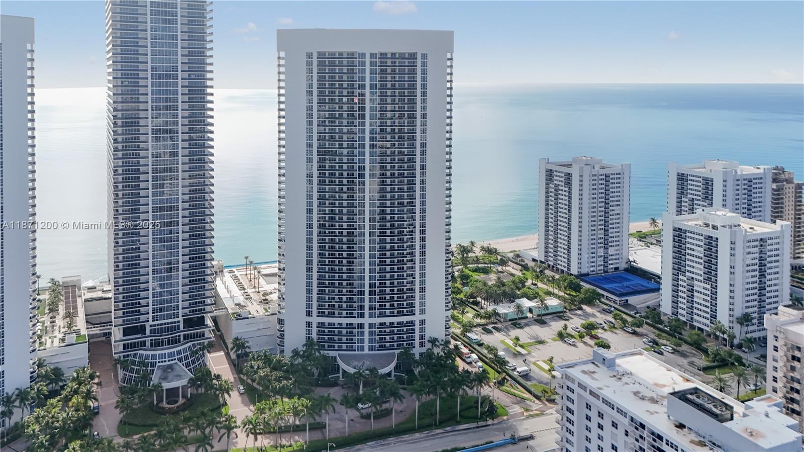 Beachfront living at its best! This 4th-floor corner condo at the Beach Club offers 1,782 sq. ft., 2 beds, 2 baths, and stunning southeast views of the ocean, park & Intracoastal. Flooded with natural light, it features custom closets, blinds, and a spacious living area with option to create a den/office. Enjoy an oversized wraparound balcony perfect for entertaining or relaxing with ocean breezes. Step outside to Hallandale’s beautiful beach and indulge in resort-style amenities including multiple pools, spa, fitness center & valet. Convenient parking on 3rd floor. Luxury living right on the sand!