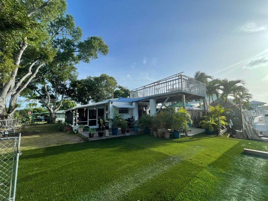 This beautifully updated home sits on a spacious 5,000 sq. ft. corner lot along a canal, offering serene views of Tarpon Basin from the elevated sundeck. Recent upgrades include a newer central AC, tankless water heater, laminate flooring, artificial grass, a 6x12 storage shed, and remodeled bathrooms. The outdoor living is exceptional, with a screened porch and sundeck perfect for relaxing or entertaining. A well-placed jacuzzi provides stunning canal views for evening unwinding. The fully fenced yard offers ample parking for boats, trailers, and water toys. Located in sought-after Key Largo Village, enjoy a private beach and two boat ramps with direct Bay access—one just steps away! Centrally located near restaurants and shops.