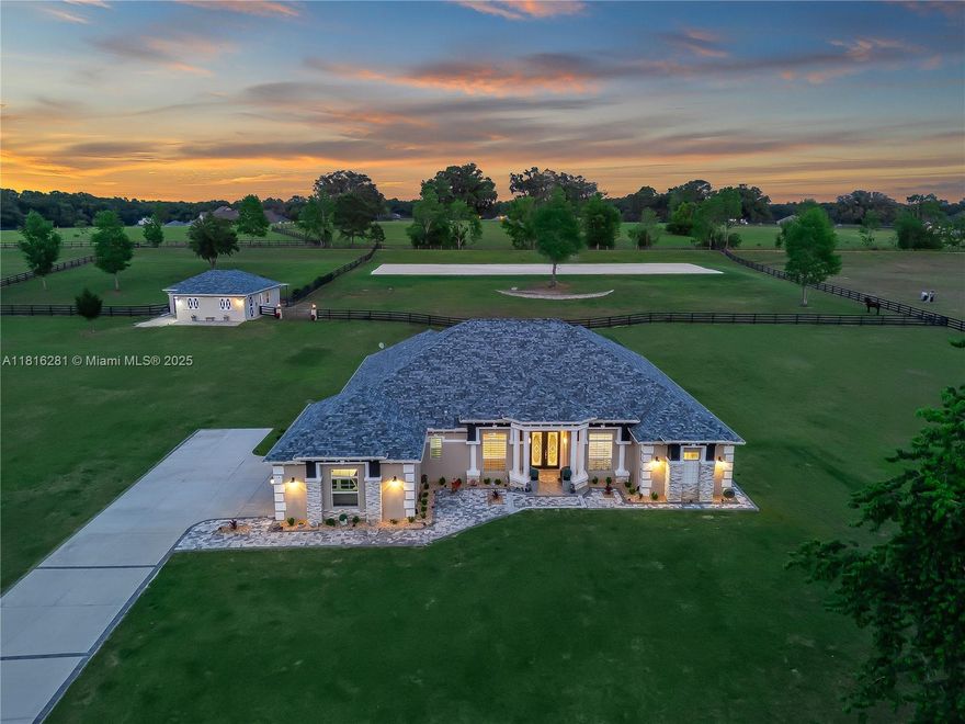 Since its last purchase, this 5.25-acre Ocala property has been extensively upgraded with major land, equestrian, and residential improvements. The entire rear portion of the property was professionally regraded, and an approximately 80’ x 220’ riding arena was added with a full irrigation and sprinkler system. All fencing throughout the property has been replaced, and a solar-powered gated entrance was installed. A 2023 custom concrete block barn was constructed, featuring oversized stalls, an air-conditioned tack room, wash stall, luxury rubber pavers, and designer RH chandeliers. Additional exterior upgrades include new exterior paint, a whole-house generator with a 500-gallon propane tank, added electrical panels, RV hookup, POE security system, Tesla EV charger, and water softener system, contributing to low utility costs. Interior improvements include fresh interior paint throughout, updated light fixtures and chandeliers, and handicap-accessible French entry doors. Outdoor living was further enhanced with the addition of a 2022 saltwater pool with dual waterfalls and a screened lanai overlooking the riding arena and rolling pastures. Conveniently located just minutes from downtown Ocala and under 20 minutes from the World Equestrian Center.
