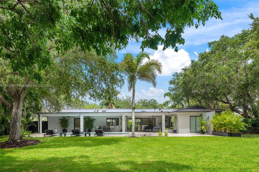 Meticulously redesigned with luxury finishes and impeccable taste—this home is move-in ready and has never been lived in. Located on a unique oversized 21,875 sq ft corner lot, surrounded by lush landscaping and majestic trees that provide exceptional privacy. Features 5 bedrooms, 3.5 bathrooms, and 2,438 sq ft under A/C (per builder). Open living, dining, and kitchen showcasing custom elements not commonly found on the market: natural stone, wood accents, and stainless steel appliances. The primary suite includes a built-in bookshelf, custom walk-in closet, and spa-like bath. Second suite with cabana bath. Expansive 55-ft covered terrace creates an elegant outdoor living and dining area. Impact windows, new metal roof, 1-car garage with laundry. A rare market gem.