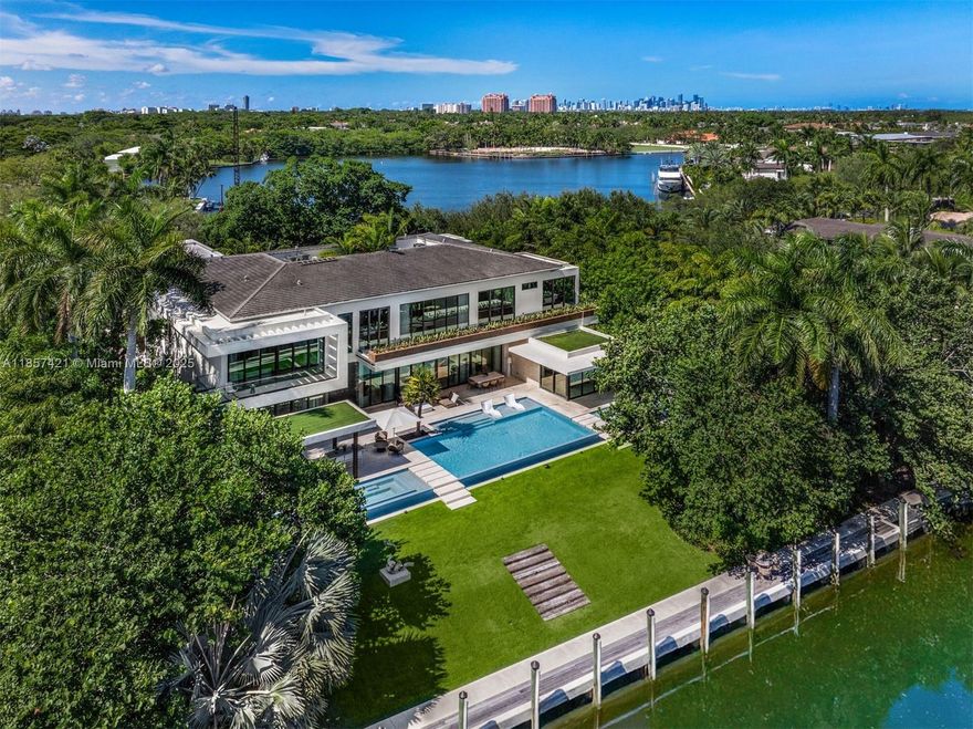 Situated in a prestigious waterfront enclave, this extraordinary 8BR, 8.3BA estate by renowned designer Hugo Mijares sits on a 41,485 SF lot, offering unmatched luxury and style. A grand entrance opens to soaring ceilings with custom details, spiral staircase, elevator, and floor-to-ceiling impact glass. The chef’s kitchen boasts dual islands, top-tier appliances, and a walk-in pantry, while the formal living/dining areas feature a double-sided marble fireplace and custom bar with wine room. The main suite includes dual walk-in closets, spa bath, and terrace views. Outdoors, enjoy lush grounds, with infinity saltwater pool, summer kitchen, and multiple terraces. Additional highlights include a 4-car garage, gym, office, guest quarters, Crestron smart home, generator, and security system.