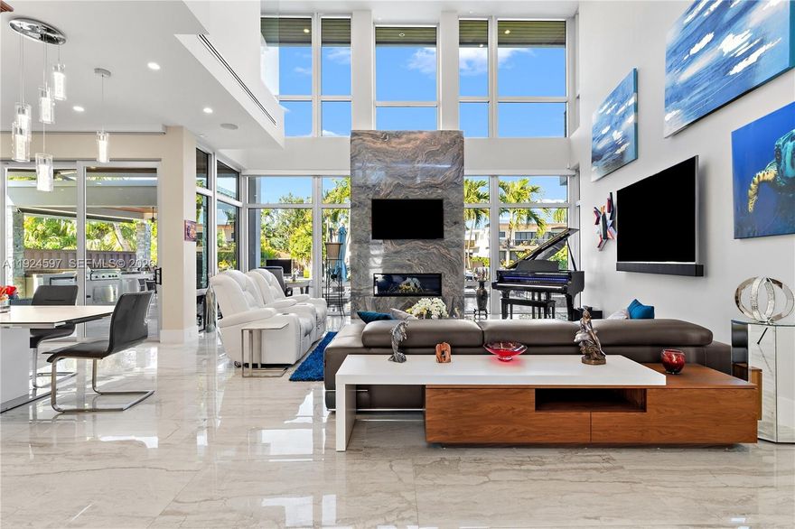 A striking modern waterfront estate completed in 2019 by Barron Construction and architect Kevin Akey. Expertly elevated on 54 pilings, this residence seamlessly blends cutting-edge technology with refined design, featuring Control4 smart-home automation, Sonos audio, a whole-house generator, and exceptional custom finishes throughout. Dramatic 23-foot ceilings, a sculptural floating staircase, and a sleek glass walkway create a breathtaking architectural statement. The chef’s kitchen is outfitted with Sub-Zero and JennAir appliances, while the first-floor primary suite delivers a true spa-like retreat. Outdoor living is equally impressive, offering an 80-foot Trex dock with direct ocean access, a resort-style heated pool and spa, manicured turf grounds, and a gated driveway accommodating up to 11 vehicles.