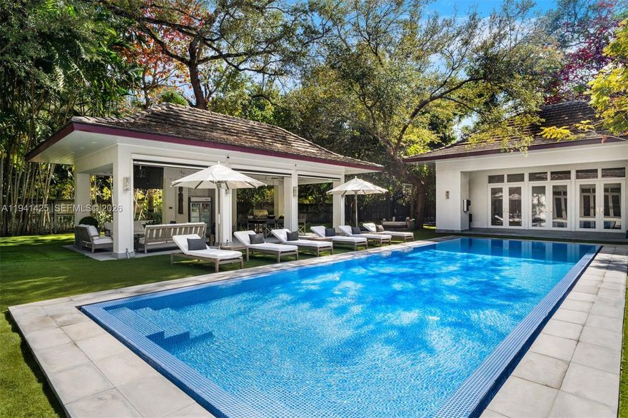 Set behind lush landscaping on approximately 1.1 acres in South Coconut Grove, this expansive one-story residence delivers 11,766 total SF with 6 bedrooms, 7 full bathrooms, and a powder room. Designed for comfort and effortless entertaining, the home showcases 12-foot ceilings, wide-plank wood floors, impact French doors, and refined architectural detailing throughout. Multiple living areas include formal and casual spaces, a wet bar, staff quarters, and a showpiece kitchen outfitted with custom cabinetry, quartz surfaces, a walk-in pantry, and a full set of premium Wolf, Sub-Zero, and Miele appliances. Two generous primary suites feature private sitting area, office, spa-style marble baths, and custom walk-in closets. The outdoor setting feels like a private resort, offering covered terraces, a heated pool, a separate oversized spa, half basketball court, volleyball court, outdoor entertaining areas, and a detached guest house currently configured as a gym. Additional features include a 4-car garage, whole-home generator, advanced smart home and security systems, and expansive grounds ideal for refined Grove living.