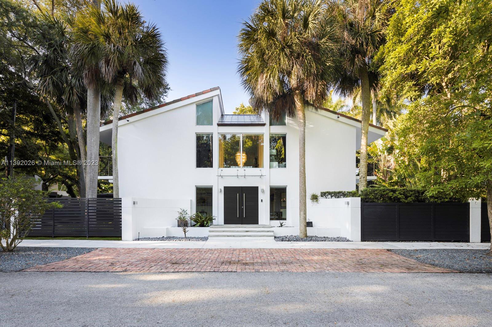 Stunning modern-style home on a quiet cul-de-sac street in prestigious North Coconut Grove. Walk to bayfront parks & marinas or bike to the Grove village center. Dramatic double-height foyer opens to light-filled living spaces w/vaulted ceilings, fireplace and stone & wood flooring throughout. Expansive formal living & dining areas + family room that opens to ultra-private, walled terrace and tropical pool. Custom kitchen features wood cabinetry, granite countertops, stainless appliances and a separate breakfast area. Ideal bedroom layout w/downstairs guest suite + 3BR/2BA upstairs- including the primary suite w/2 walk-in closets & balcony overlooking the pool & tree tops. High sea-level elevation (not in a flood zone). Just minutes drive to downtown, MIA, Key Biscayne & the Beaches.