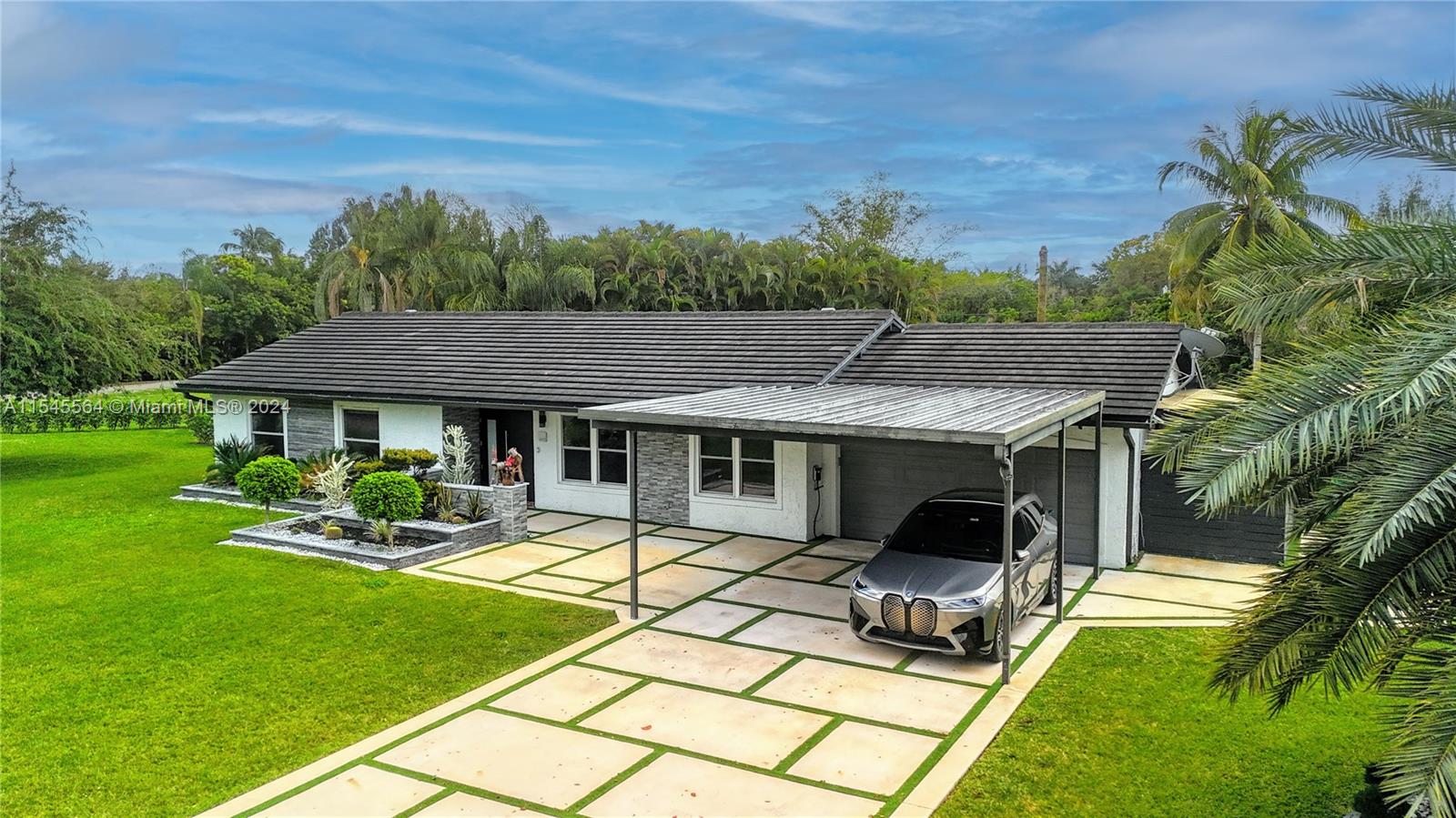 Welcome to your dream oasis! Beautifully remodeled 3/2 ranch-style home sits on an expansive, almost 30,000 sq ft lot! The kitchen features top-of-the-line Bosch appliances, ice maker and wine bar, perfect for entertaining. Plans are included to expand the master/living area for added space. All windows, doors, and garage are hurricane-rated. Home boasts a guest house with a bathroom/shower, complete with new tile floors. picturesque lakefront views and a 20 X 40 saltwater pool surrounded by travertine pool deck. The outdoor BBQ area features built-in appliances, including a KamadoJoe smoker, ideal for outdoor gatherings. Additional amenities include an outdoor shower, fire pit area, and shed. With updates like a 2018 roof, 2019 A/C, and a water heater from 2022.