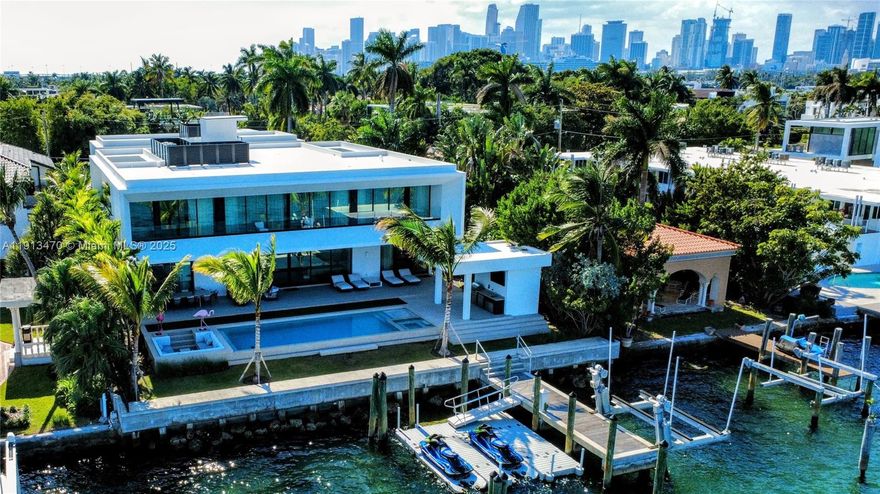 A true architectural masterpiece, this newly completed waterfront residence on the exclusive, guard-gated Hibiscus Island embodies the pinnacle of refined Miami Beach living. Designed by renowned architect Kobi Karp and curated by European luxury design firm AED Planung, this contemporary estate offers 7,869 SF under air (9,178 SF total) with 6 beds, 7.5 baths on a 90-ft bayfront lot with sweeping views of the Bay, Miami, and Miami Beach. The open floor plan flows seamlessly to a resort-style outdoor area featuring an infinity-edge pool/spa, covered dining pavilion, summer kitchen, sunken lounge next to pool, and private dock. Other notable features: home automation system, elevator, movie room, gym, wine fridge, extensive rooftop terrace, separate guest house, and whole home generator.