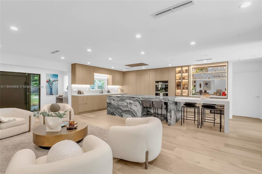 Experience luxury living in this fully renovated and expanded 2023 Pinecrest home. Gutted and reimagined with modern design and high-end finishes, this turnkey gem features a chef’s kitchen with Miele appliances, hidden walk-in pantry, and built-in bar. The spa-inspired primary suite offers a private lounge, hidden office, and luxe bath. Two oversized en-suite bedrooms downstairs, plus two additional bedrooms, one used as a gym with sauna. Indoor laundry, heated pool, and sleek outdoor kitchen. Newer roof, impact windows, updated plumbing, HVAC, and designer details throughout. A rare Pinecrest find for buyers wanting a new construction feel without the wait.