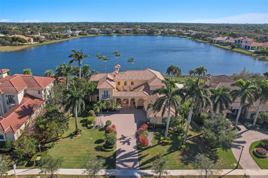 Casa Bella Vista is set on 125ft of long lake views in the prestigious 24/7 guard-gated Windmill Reserve. The estate offers a timeless design with an opportunity to personalize. The backyard oasis features a heated pool & spa, covered summer kitchen w/ motorized screens. Inside, find 6 ensuite BDs + office, home theater, billiards room w/ built-in bar, & a wine room. The 1st floor primary suite boasts a sitting area, wet bar, dual walk-in closets, spa-like bath w/ jacuzzi, walk-through shower & his & her toilet rooms. The well-appointed kitchen features Sub-Zero & KitchenAid appliances, gas cooktop, island & butler’s pantry. Additional features include a marble fireplace, courtyard entry with water feature, & elevator. A rare chance to own in one of Weston’s most sought-after communities.