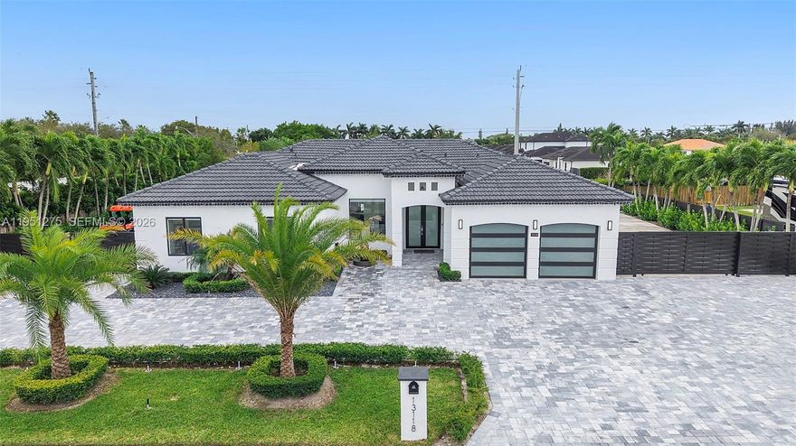 This beautifully updated pool home features sleek white porcelain tile flooring throughout and soaring high ceilings. The centerpiece of the home is a glass-enclosed wine cellar, ideal for showcasing your collection as well as the kitchen which ties up the space perfectly with extra high cabinets and island great for entertaining. High-impact windows and doors throughout the home create a space with lots of sunlight to enter the home. Outside, enjoy a the heated pool on a cool deck surrounded with high quality pavers, an outdoor kitchen area for gatherings, and a cabana bath for convenience. Plus, with double-wide gated side access on both sides, there’s ample space for your RV or boat. This is the ultimate blend of style, function, and outdoor living!
