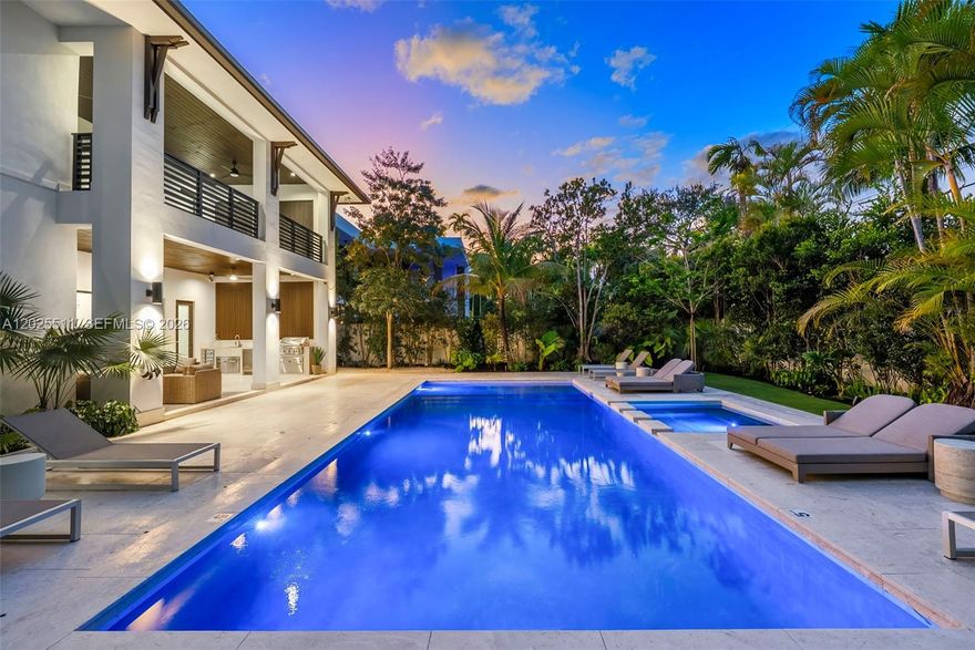 A Masterwork of Miami Modern Living
The latest creation by award-winning architect Hamed Rodriguez, where Miami modernism meets Caribbean soul. Nestled on lush tropical grounds canopied by majestic mature trees, this extraordinary villa offers 5 en-suite bedrooms and 6 baths with an effortless sense of arrival from the moment you step inside.

Walls of glass dissolve the boundary between indoors and out, drawing the eye toward covered terraces perfect for alfresco lounging and dining. Warm wood plank floors and cool limestone tiles flow throughout, while soaring ceilings and abundant natural light give every space an open, airy quality that is grand yet deeply livable.

At the heart of the home, a chef's kitchen of exceptional caliber features custom cabinetry, a dramatic 12-foot quartz island with waterfall finish, and a full suite of high-end appliances including built-in oven/microwave combo, professional cooktop, wall hood, dishwasher, and wine cooler — ideal for hosting private chef dinners.

Outside, coral stone floors and accent walls evoke quintessential Miami elegance. A fully equipped summer kitchen and resort-style pool with spa — straight from the pages of a design magazine — invite endless hours under the South Florida sun.