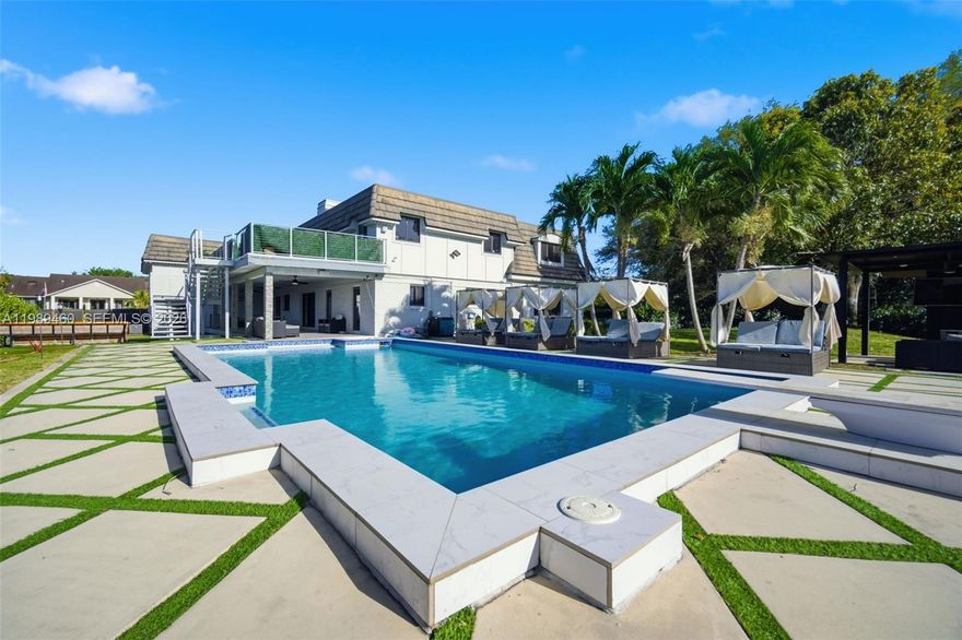 Discover a truly unique Cape Cod–style residence with striking contemporary flair, ideally nestled on a quiet cul-de-sac in the heart of Davie. Completely renovated with a focus on modern luxury and everyday comfort, this exceptional home showcases open-concept living spaces, soaring ceilings, and sleek, high-end finishes throughout.
Designed for both entertaining and relaxed living, the home features a chef’s kitchen, a sophisticated glass-enclosed bar, and a dedicated theater room. The spacious primary suite offers a private retreat with a dry bar, a large walk-in closet, and a beautifully appointed bath. A home elevator adds an extra layer of convenience and accessibility.
Step outside to an expansive resort-style setting where a sparkling pool overlooks tranquil lake views. Enjoy your own private tennis court—also lined for basketball—a charming gazebo seating area, and generous open space perfect for gatherings. With a private dock, you can kayak, paddleboard, or water cycle right from your backyard.
Set in one of Broward County’s most desirable communities, Davie is known for its unique blend of western charm and modern living, excellent schools, and proximity to parks, shopping, and dining—all just a short drive from Miami. Offering three garage spaces and thoughtfully designed for a luxury lifestyle, this one-of-a-kind property is even more impressive in person.