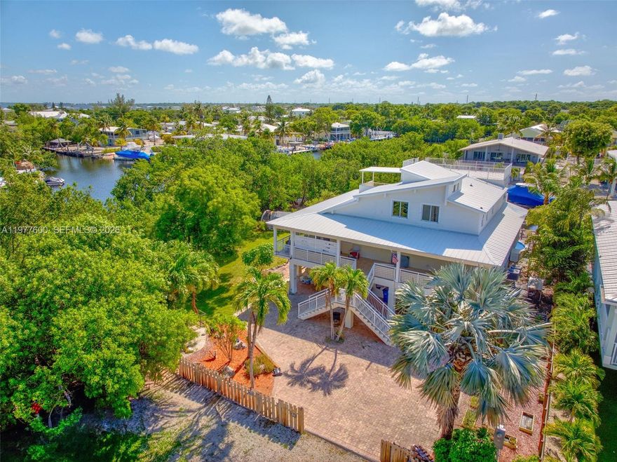 Embrace the open bright treehouse feel of this renovated home tucked away on a dead end street in sought after Twin Lakes subdivision. 40 minutes from Miami yet feeling like a tropical Oasis. Catch the breeze from the wrap around porches or the sunset from the large rooftop patio with a view of Blackwater Sound. The 65' Trex dock can be home to your boat, ski's and other water toys on the deep and wide canal. From the vaulted ceilings, beautiful eucalyptus flooring, large master suite, whole house Generac generator you will feel like you are on vacation every day. The salt water above ground pool surrounded by a Trex deck is easy to care for and is wonderful to relax in after a day of boating.