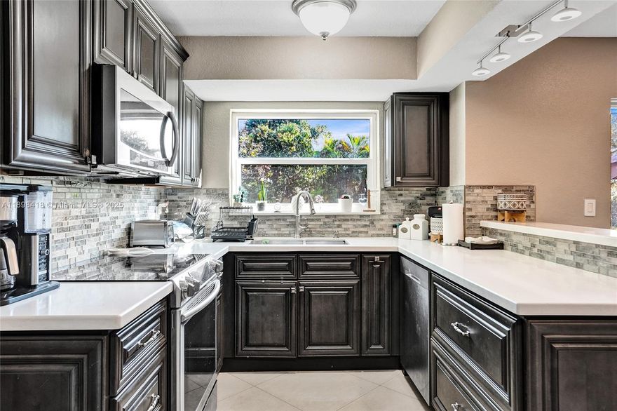 Welcome! Beautifully updated 4-bedroom, 2.5-bathroom home in a desirable neighborhood with no HOA. You’ll love the large front porch, perfect for sipping your morning coffee, greeting neighbors or unwinding. Inside, enjoy soaring high ceilings and an open floor plan with large white tile flooring throughout, creating a bright and modern feel. The updated kitchen features plenty of cabinetry and space for entertaining. Hurricane-impact windows and front door for peace of mind. Garage has been converted into living space, offering flexibility for a playroom, office, gym or can easily be converted back into a garage. Step outside to your backyard oasis, where you can enjoy outdoor living along a scenic canal—perfect for fishing, boating, or breathtaking sunsets. New tankless water heater!