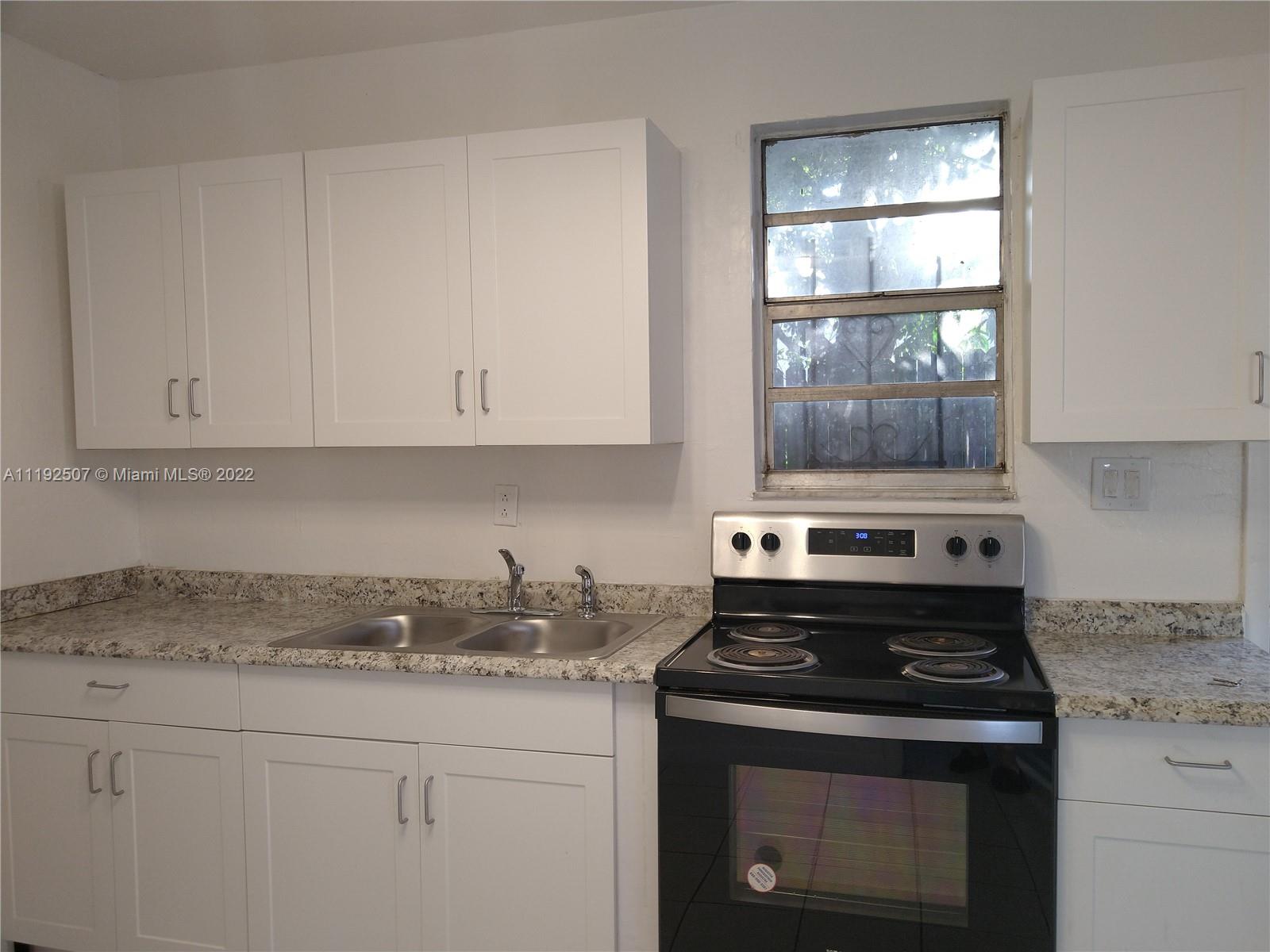 Kitchen with new cabinets - Stainless Steel Refrigerator and Stove - Renovated Bathroom.