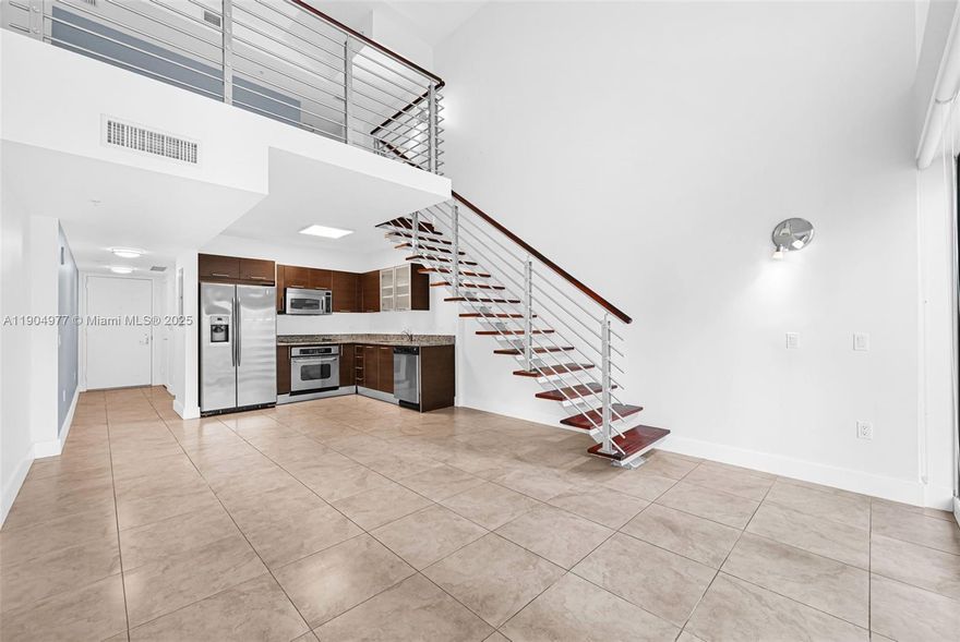 Loft-style 1-bedroom, 1.5-bath residence at Brickell on the River South. The bi-level layout features double-height ceilings, floor-to-ceiling windows, and an open kitchen with stainless steel appliances, granite counters, and European cabinetry. The upstairs bedroom includes a walk-in closet and en-suite bath. Washer/dryer in-unit and assigned parking included. Building amenities include a 24-hour concierge, 11th-floor infinity pool, riverfront fitness center, spa, business center, and resident lounge. Located steps from the Metromover, Brickell City Centre, and Mary Brickell Village, with easy access to dining, shopping, and transit in one of Miami's fastest-growing neighborhoods.