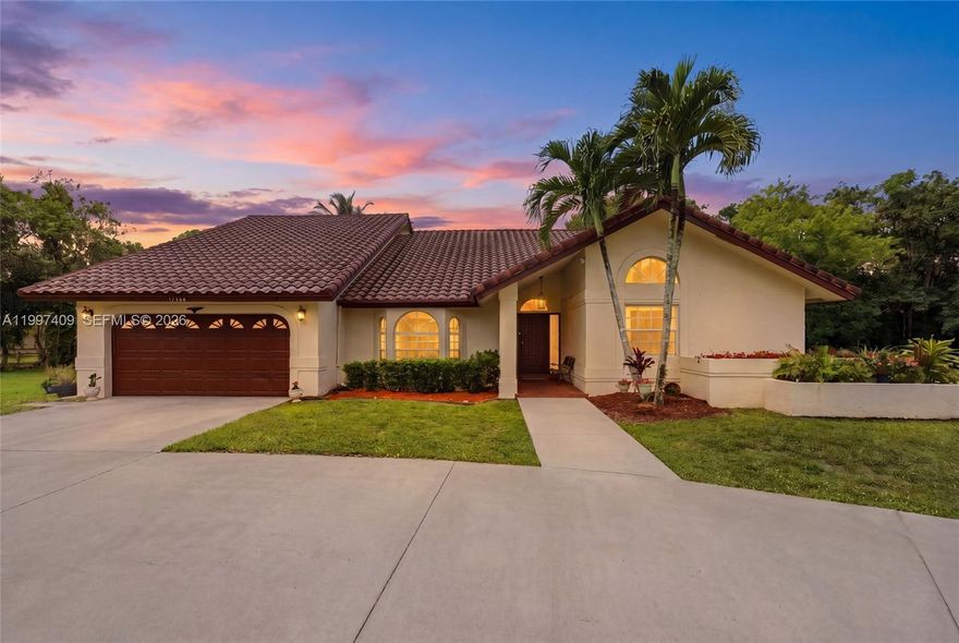 Rare Opportunity In Plantation Acres! Situated On Over An Acre Of Lush Land And Over 3,000 Sqft This Spacious 4 Bed/ 2.5 Bath Pool Home Has A 2 Car Garage. Large Open Layout. Vaulted Ceilings. Lots Of Natural Light Throughout. Updated Eat-in Kitchen Has Granite Countertops, Tumbled Marble Backsplash, Cooktop. SS Appliances, Wall Oven, Warming Drawer. Kitchen Island, And White Wood Cabinets. Family Room Has Built-ins And Overlooks Pool And Yard Views. Primary Suite Boasts Its Vaulted Ceiling With Ceiling Fan, Walk-in Closet, And Laminate Flooring Overlooking The Pool. Primary Bathroom Has Dual Vanities, Separate Shower/Tub, Frameless Enclosure, And Slate Titles. Hall Bathroom Has Large Wood Vanity With White Countertop, Closet For Linen Storage, And A Frameless Walk-in Shower. Step Through Elegant French Doors To Discover A Private Fenced Backyard Oasis, Featuring A Newly Updated Sparkling Pool With Custom Rock Waterfall On A Travertine Patio Perfect For Both Tranquil Afternoons And Outdoor Entertaining. Mango Tree. Recessed Lighting. Roof 2017. Water Heater 2018. AC 2014/2020. Two Siemens Electrical Panels. Circular Driveway To Fit 7 Cars. No HOA! Close To American Heritage, Sawgrass Mall, Shopping, Dining and Highways.  This Home Has Privacy, Land And Luxury. This One Will Not Last!!