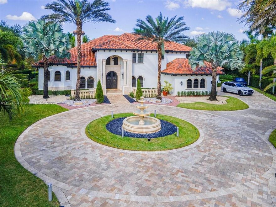Beautiful 8247 sf Mediterranean Tuscan-style villa nestled in a private gated community featuring only 34 homes. Home is situated on cul-de-sac. Features 5 bedrooms+office and 6.5 baths. Oversized primary bedroom on ground floor w/ exquisite primary ensuite. In-law/guest suite equipped with private kitchen, living room, bathroom and private entrance. Remodeled chef's kitchen with beautiful quartz countertops, high-end appliances and gas stove. 3 bedrooms upstairs all w/ attached baths. Impact windows and doors. State-of-the-art security system and Sonos speakers integrated throughout. Step outside to your private outdoor tropical oasis w/ a fully equipped summer kitchen, resort-style lagoon saltwater pool and jacuzzi overlooking a lake and beautiful sunset views. Community Tennis court.